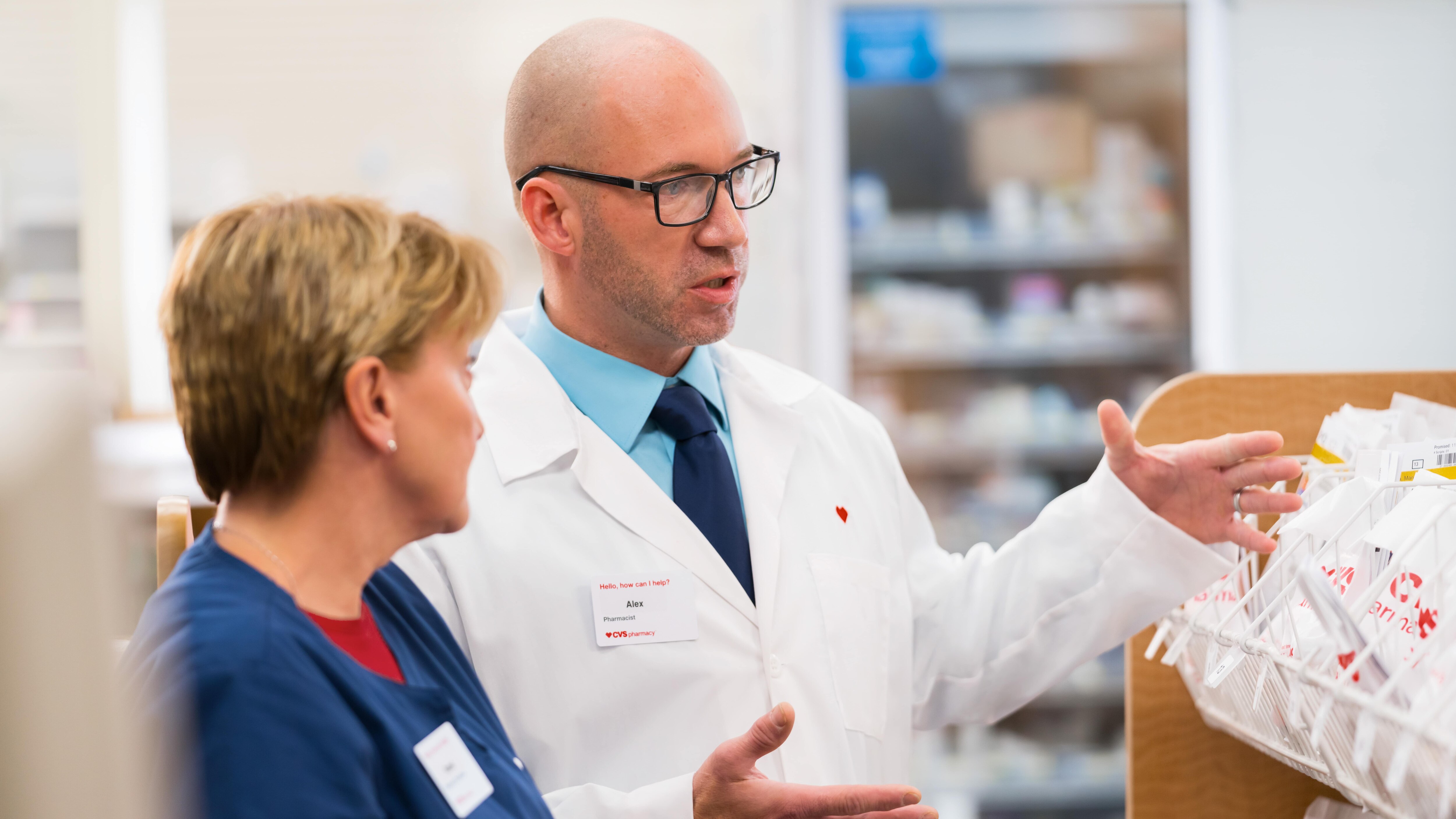 A pharmacist talking with a pharmacy technician