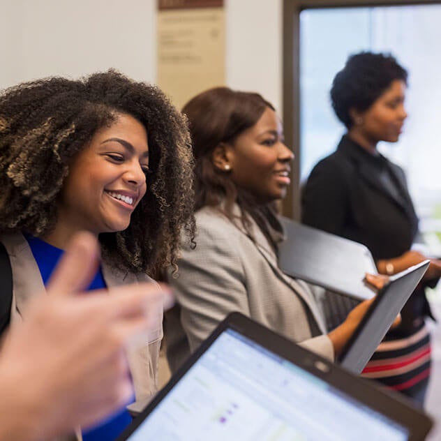 Group of women in a line holding laptops
