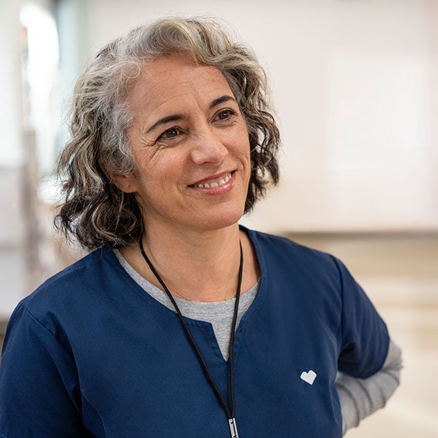 Female CVS employee wearing blue scrubs and smiling