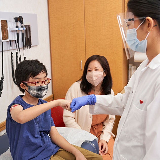 Doctor fist bumping child patient in doctors office