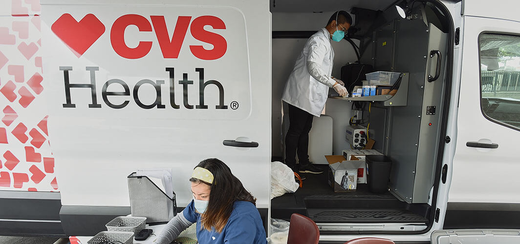 CVS Health van parked with two employees working