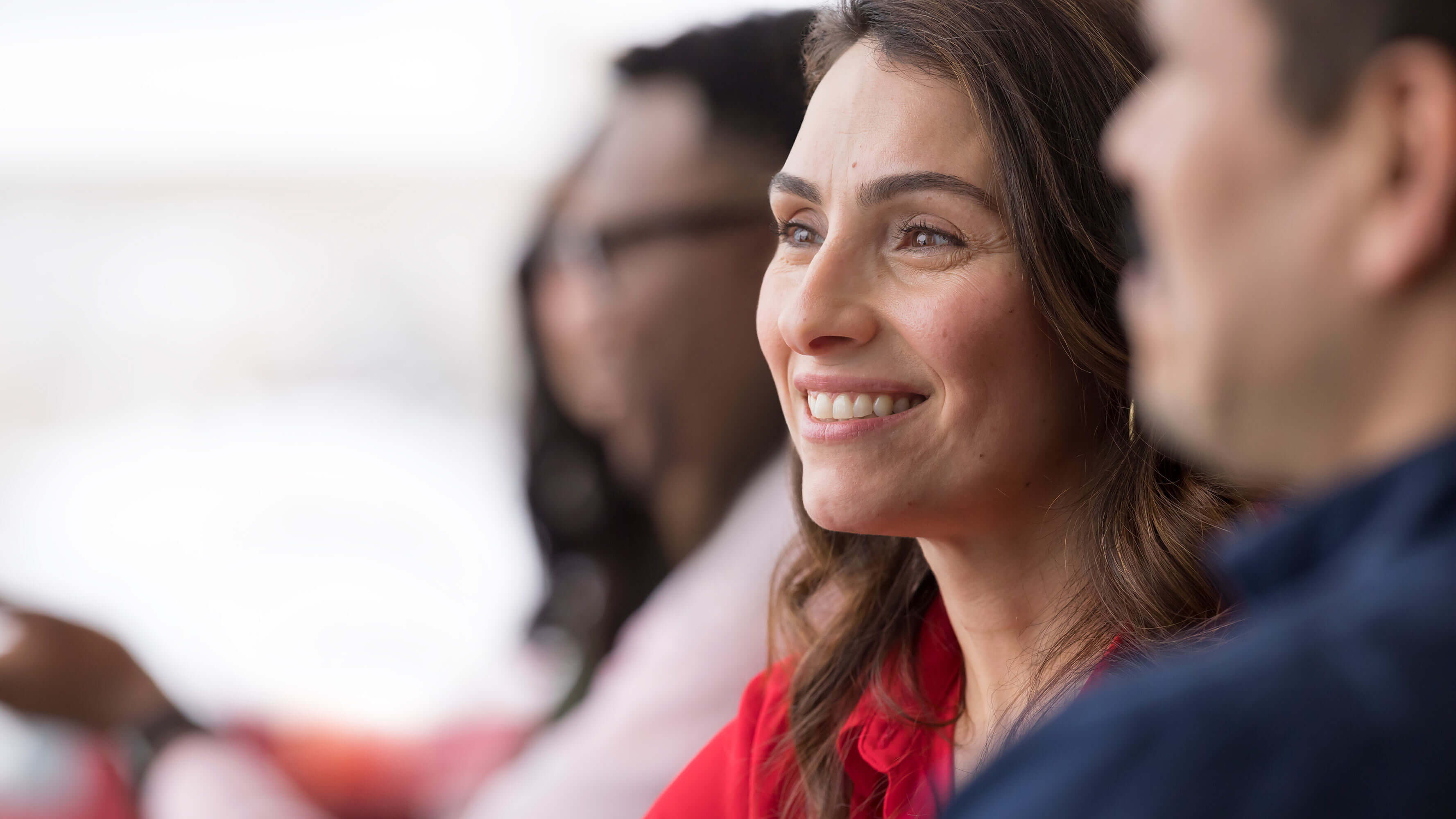 A close-up photo shows a female CVS Health employee smiling while sitting around a conference table at the company’s Woonsocket, Rhode Island headquarters.