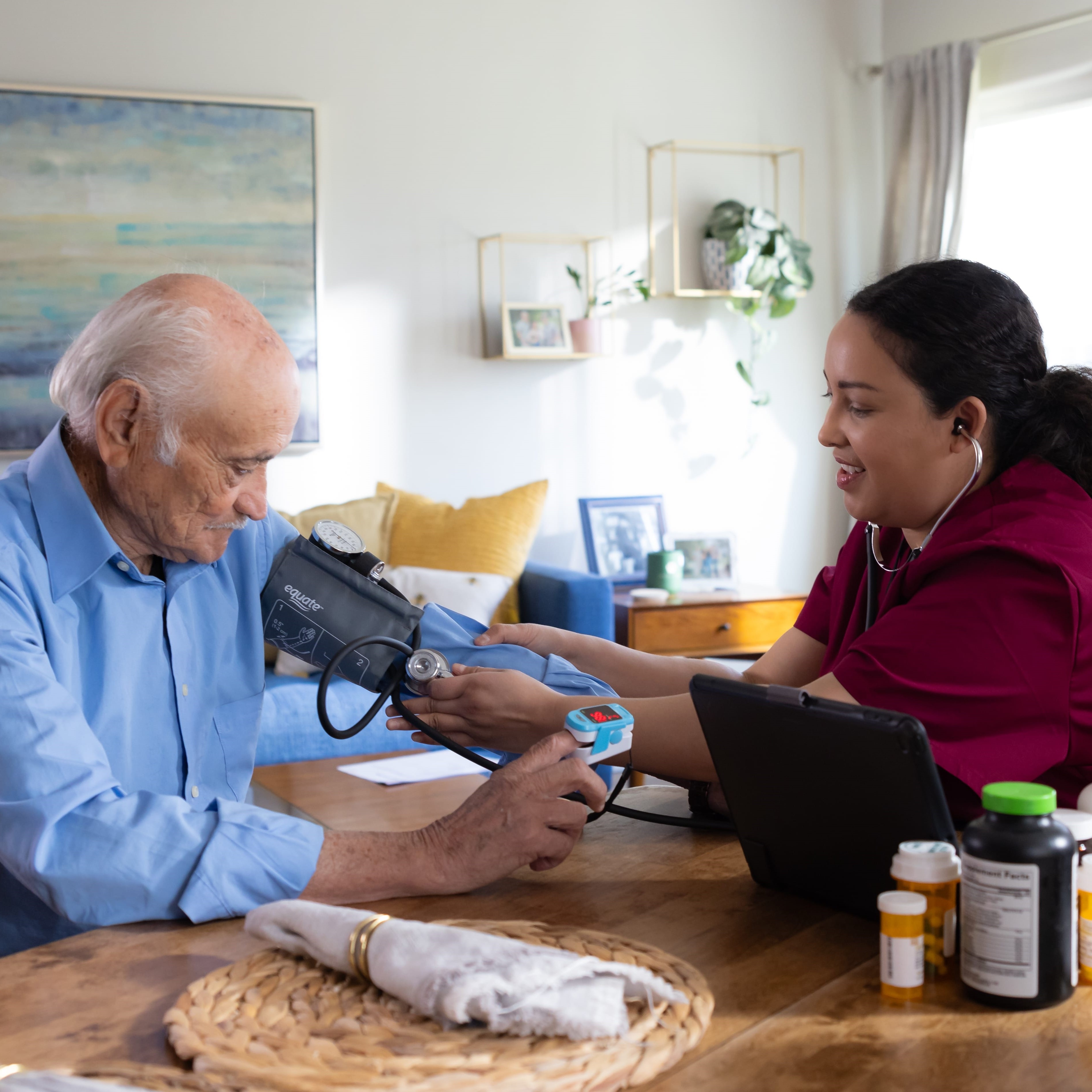 An in-home care provider take a patient's blood pressure.