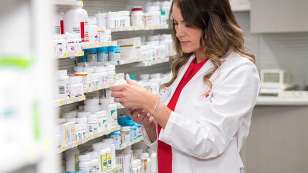 Female pharmacist filling prescriptions in CVS pharmacy