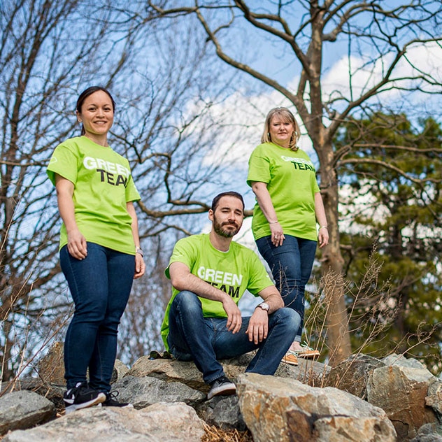 Three CVS Green Team members standing on a rock