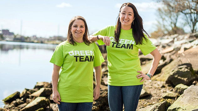 Two CVS Green Team volunteers smiling next to a lake
