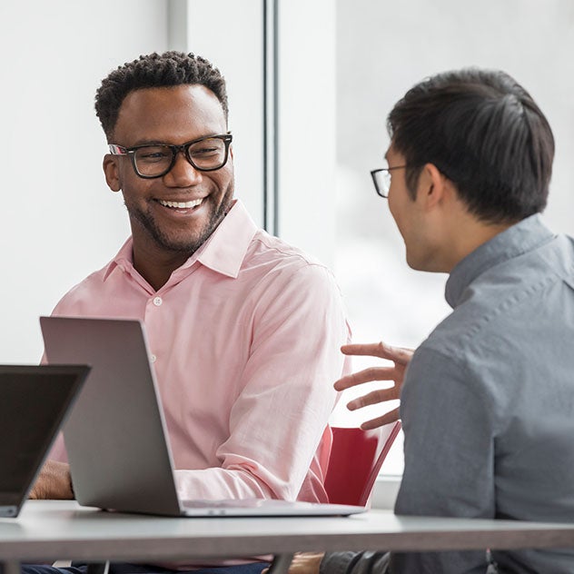 Three men having a conversation around an office table