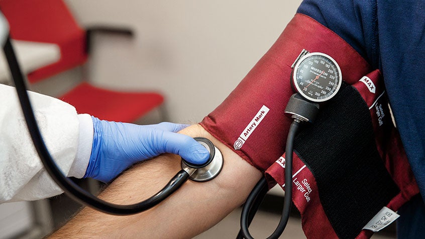 The arm of a person getting their blood pressure checked by a CVS professional