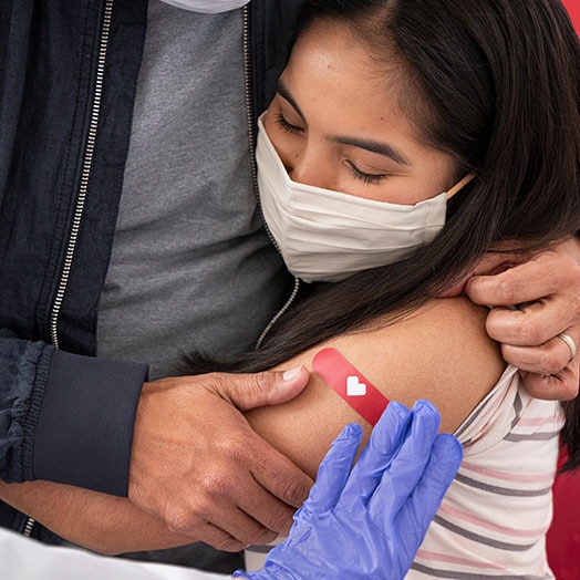 A woman hugging a man after a vaccination