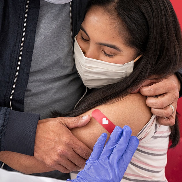 A woman hugging a man after a vaccination
