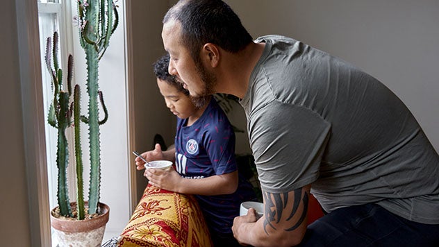 A father and his young son looking out a window