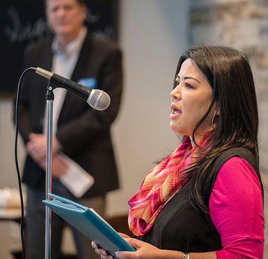 Woman giving a speech into a microphone