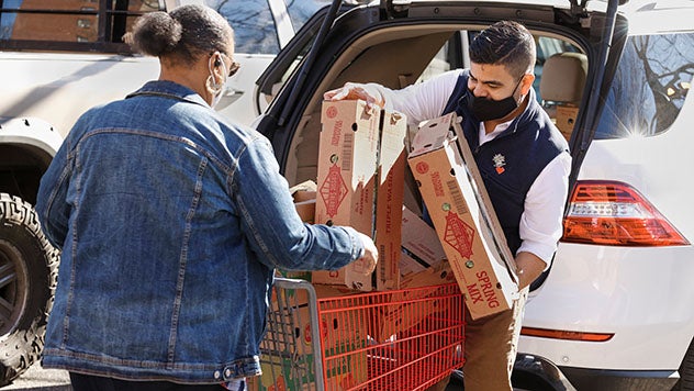 Man and woman putting groceries into a shopping cart