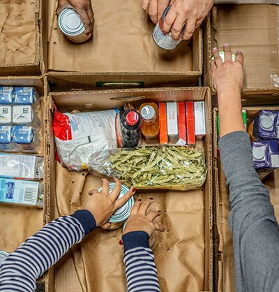 Overhead shot of people packing food in boxes at a food bank