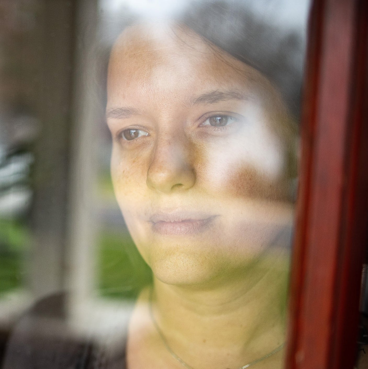 Woman staring outside through a window