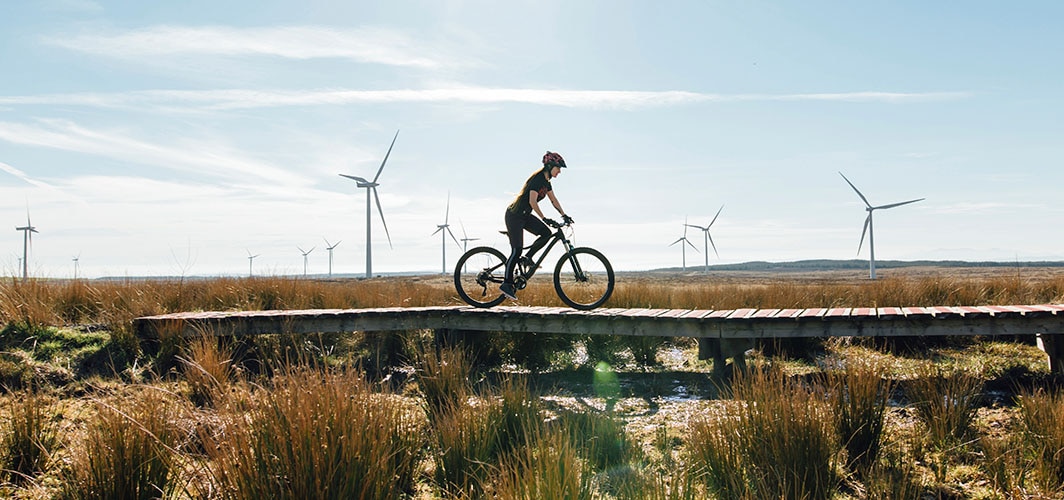 person riding a bike with windmills in the distance