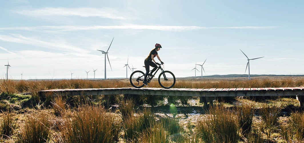 person riding a bike with windmills in the distance