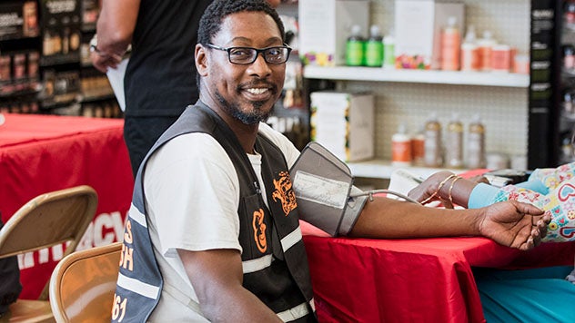 Man smiling while getting his blood pressure taken