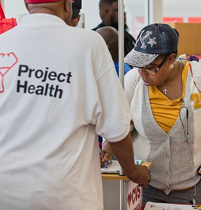 Woman signing in at a Project Health event