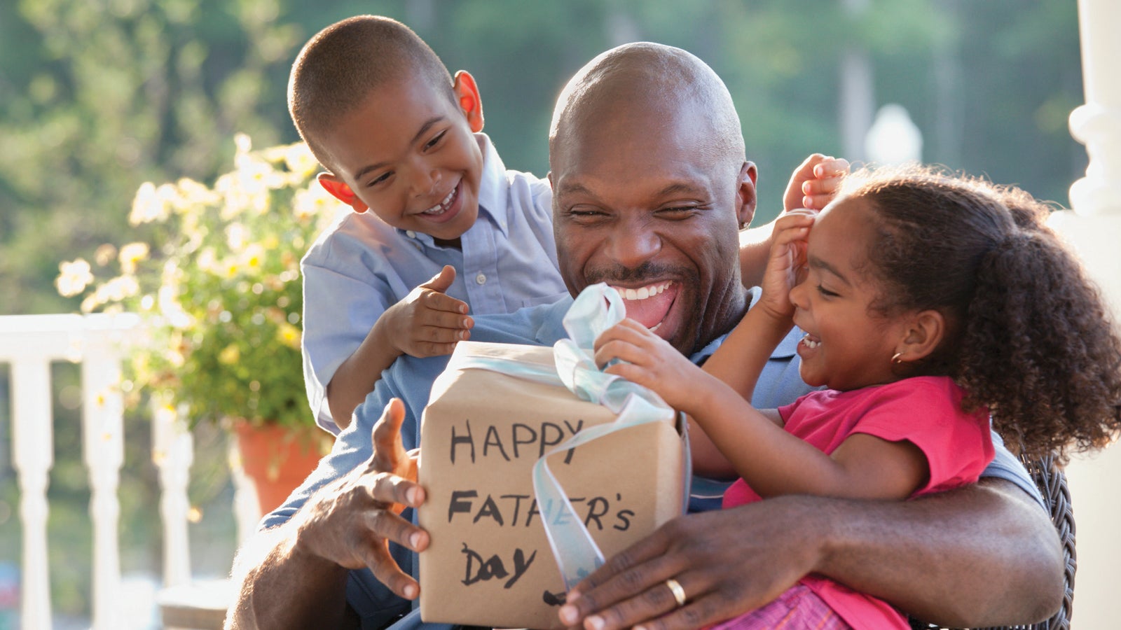 A father and his children open a Father's Day gift together.