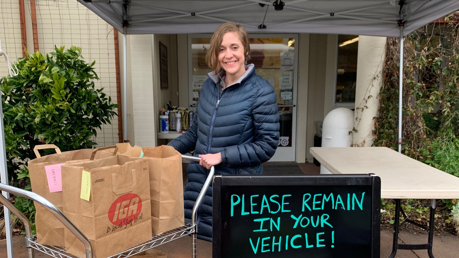 A volunteer prepares bags of food for donation.