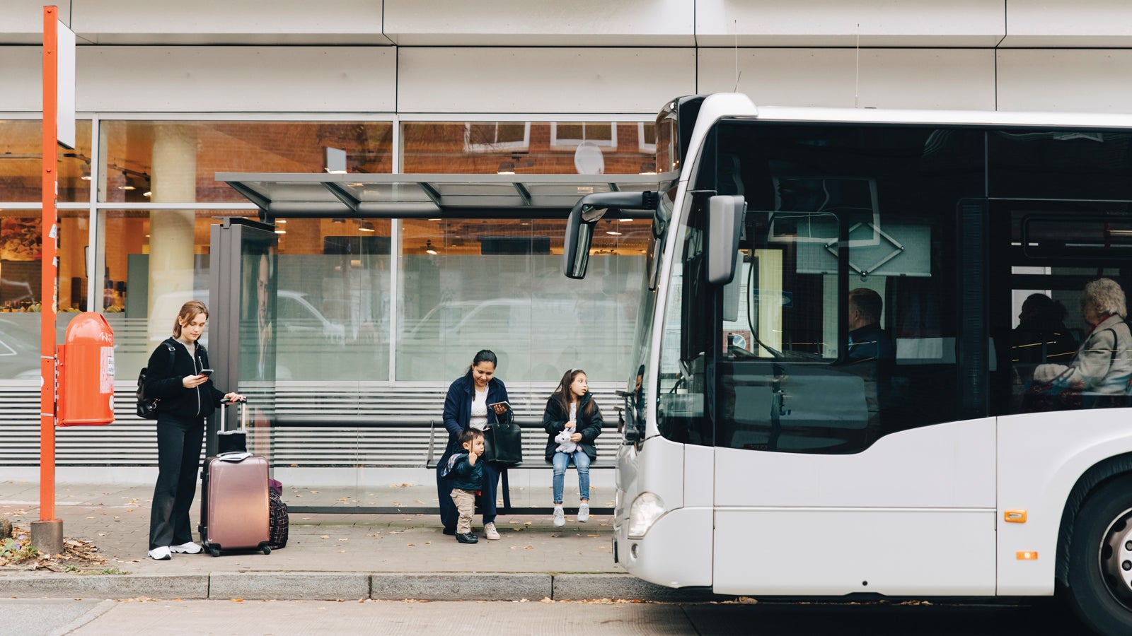 A family waiting at a bus stop