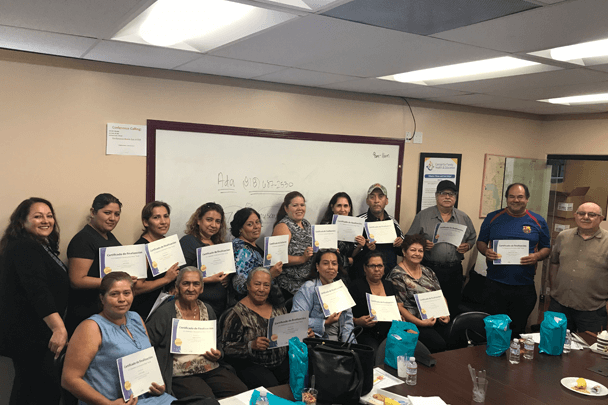 Program graduates pose with their certificates of completion.