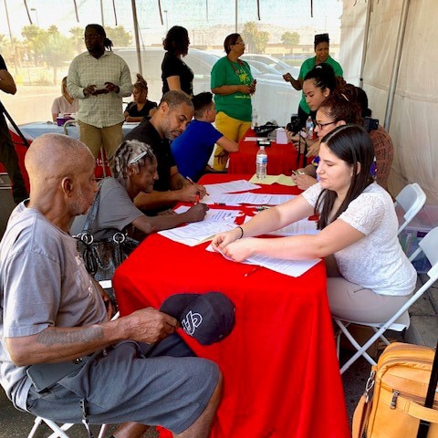 A man and a woman check into health screening event.