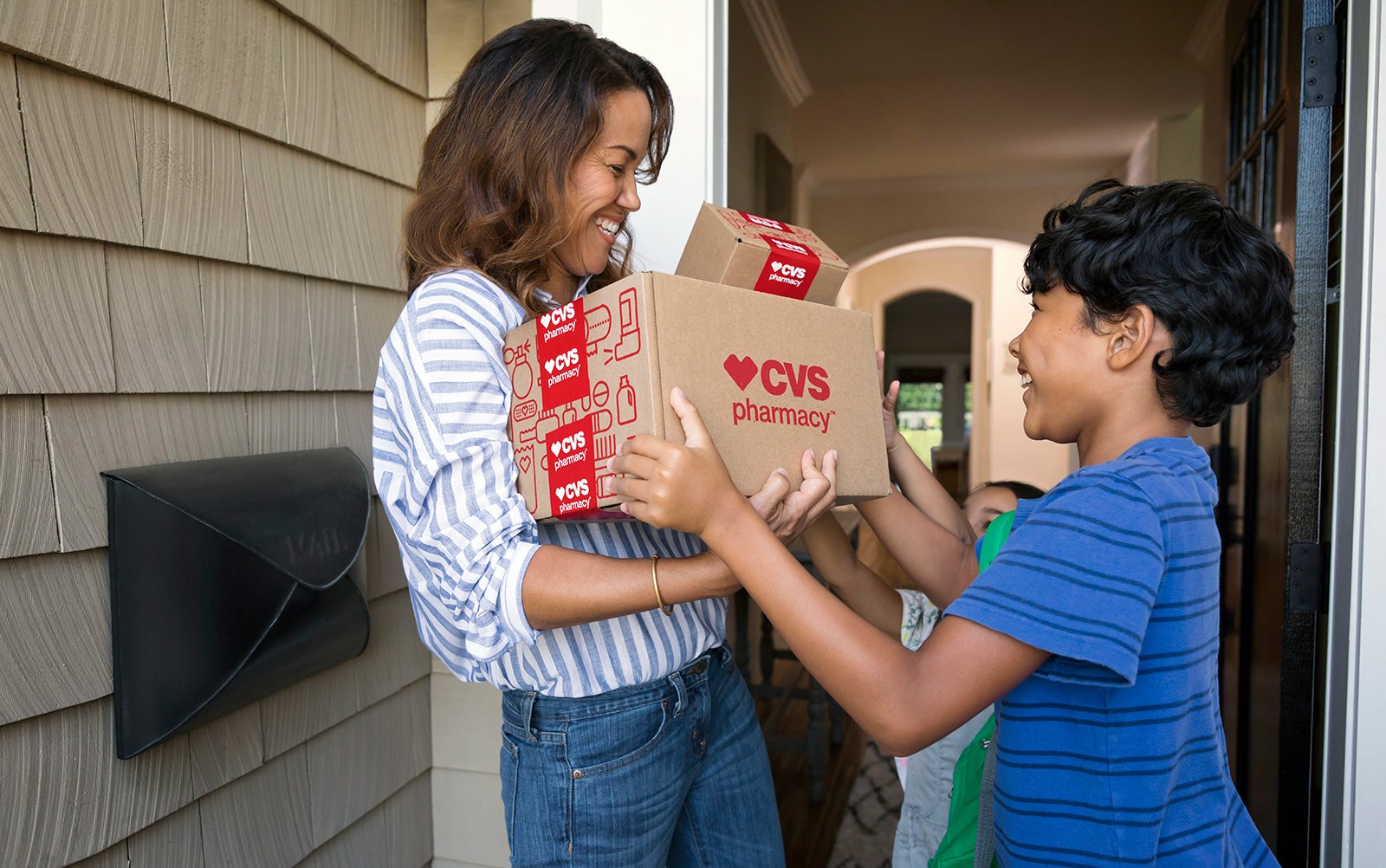 Woman and boy with CVS Pharmacy delivery.