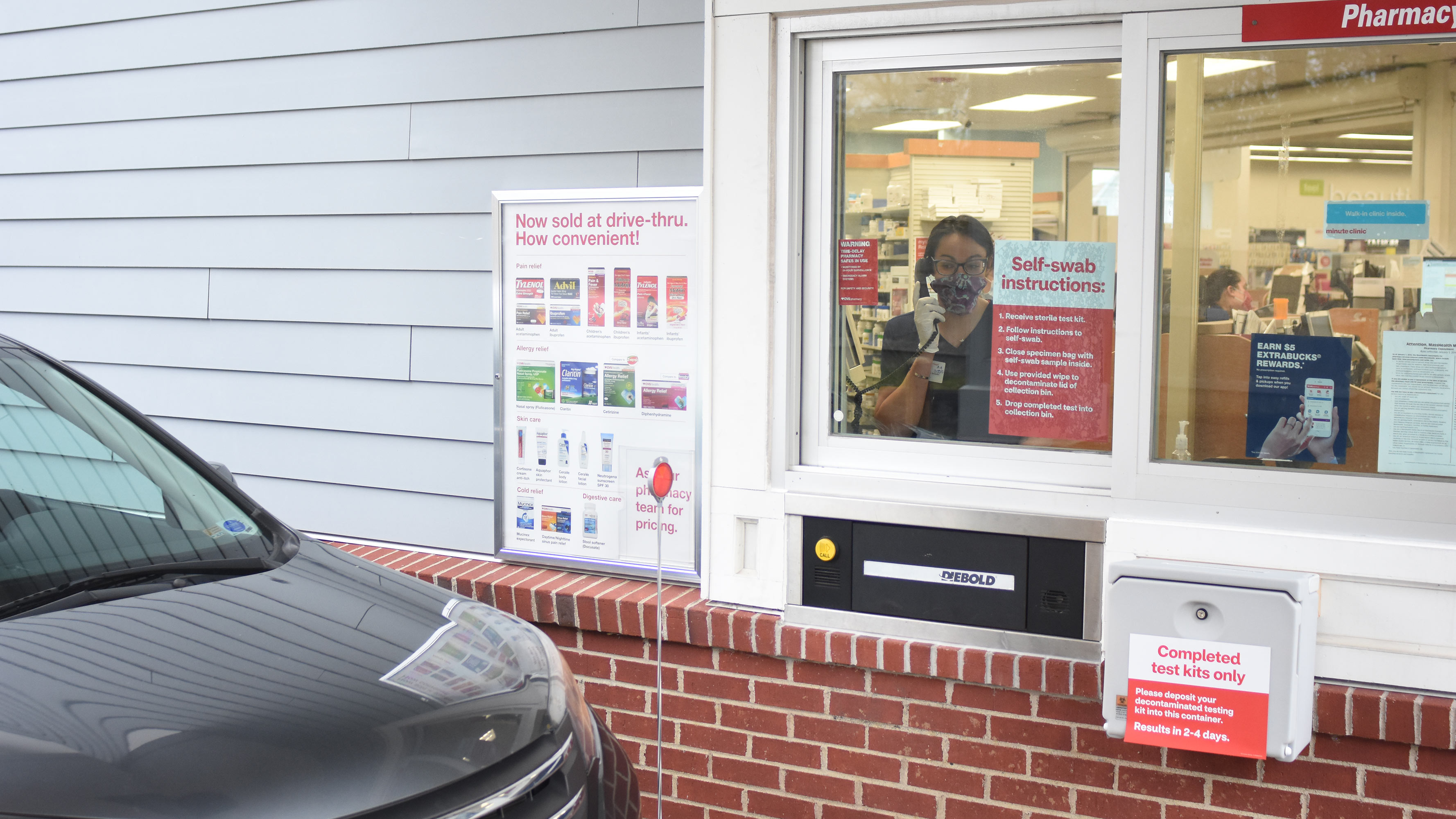 A CVS pharmacists speaks to a customer in the drive-thru at a CVS Pharmacy location.