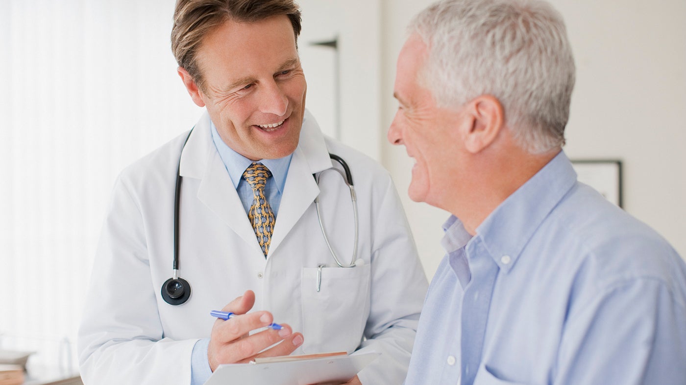 A doctor supporting and counseling a patient in an examination room.