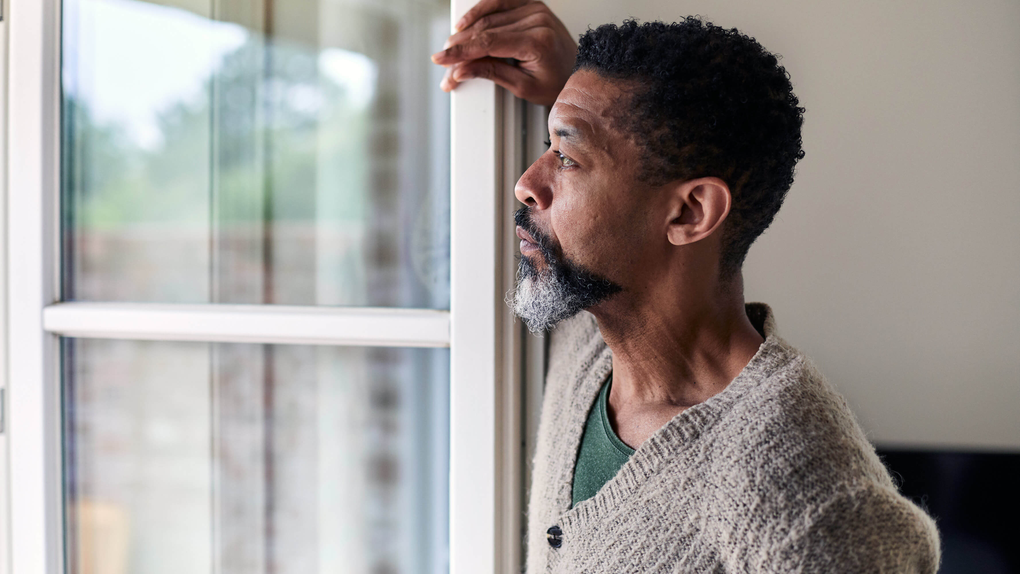 A man gazes out of a window.