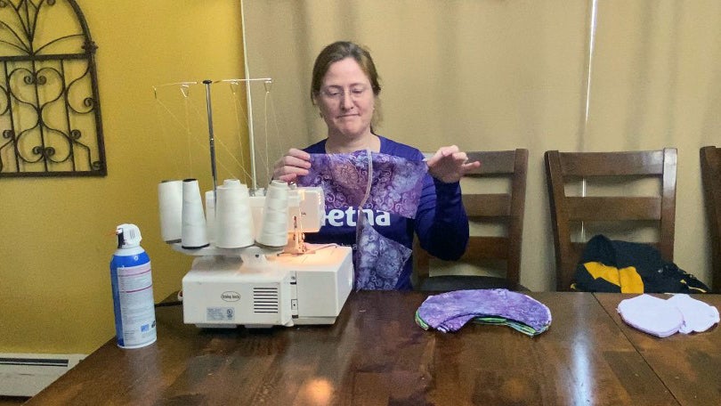 Bo Hallowell, making face masks using a sewing machine.