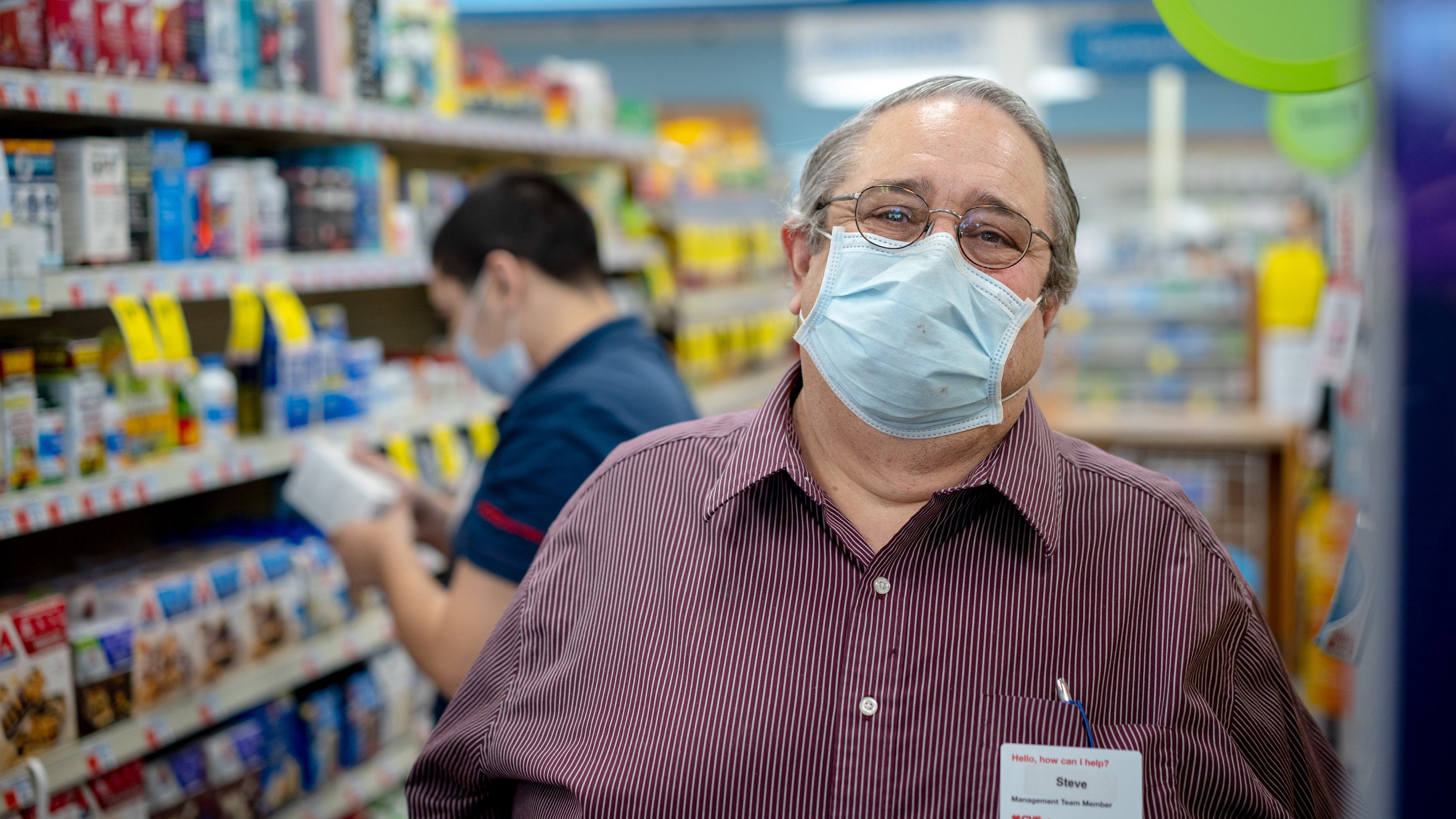 Steve Normandy standing in an aisle of the CVS Pharmacy in which he works.