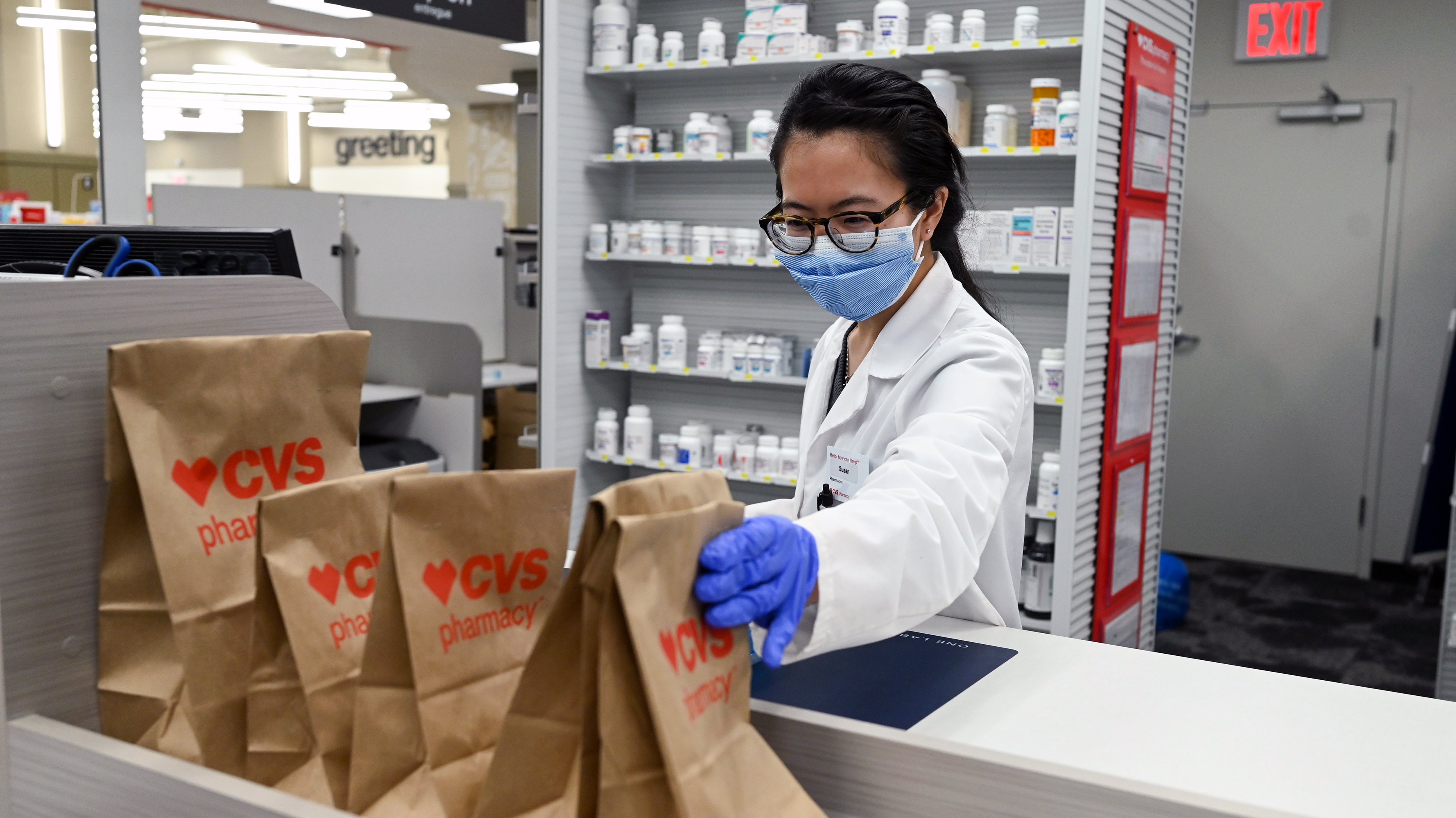 A CVS pharmacist prepares prescriptions while wearing personal protective equipment (PPE).
