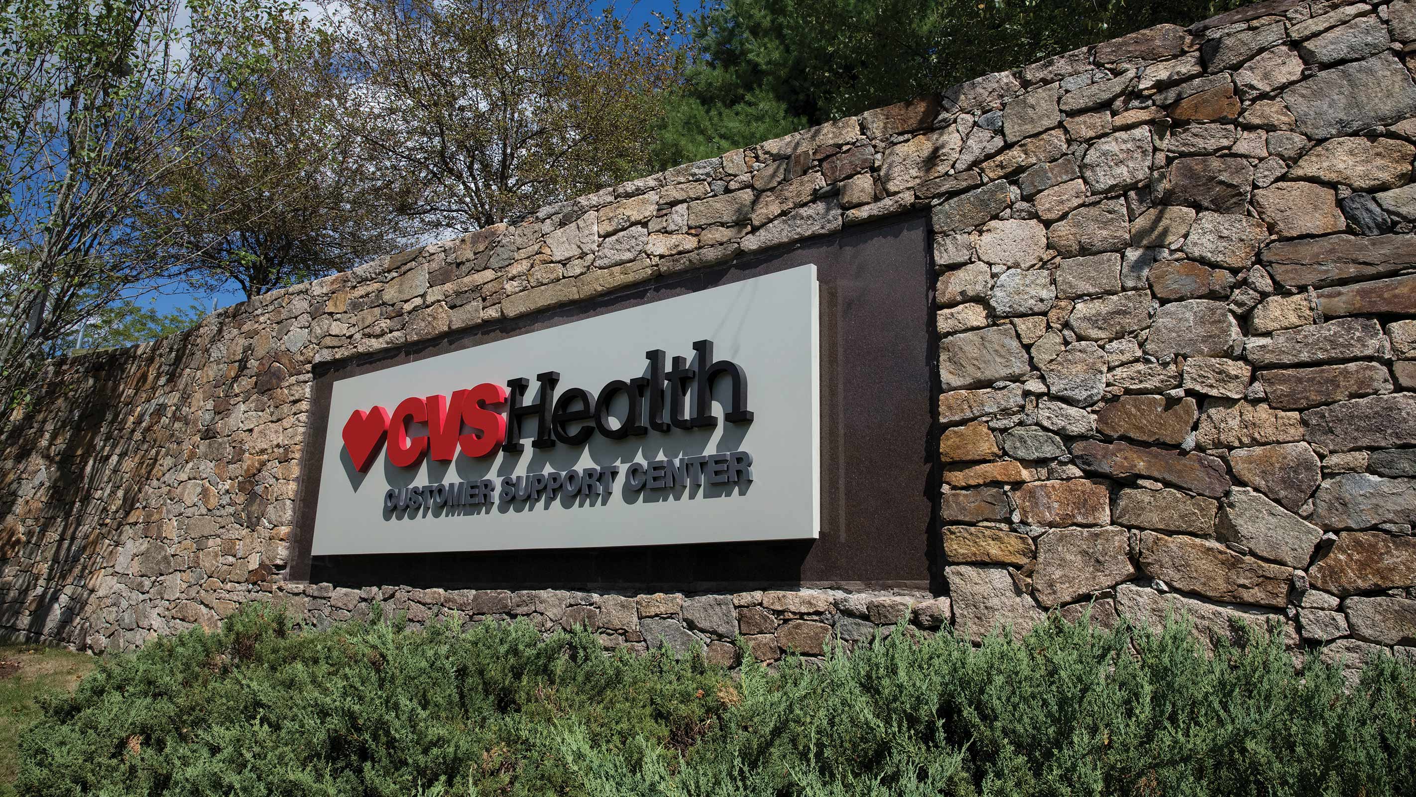 A photo of the exterior sign on the stone wall, outside of the CVS Health Customer Service Center in Woonsocket, Rhode Island.