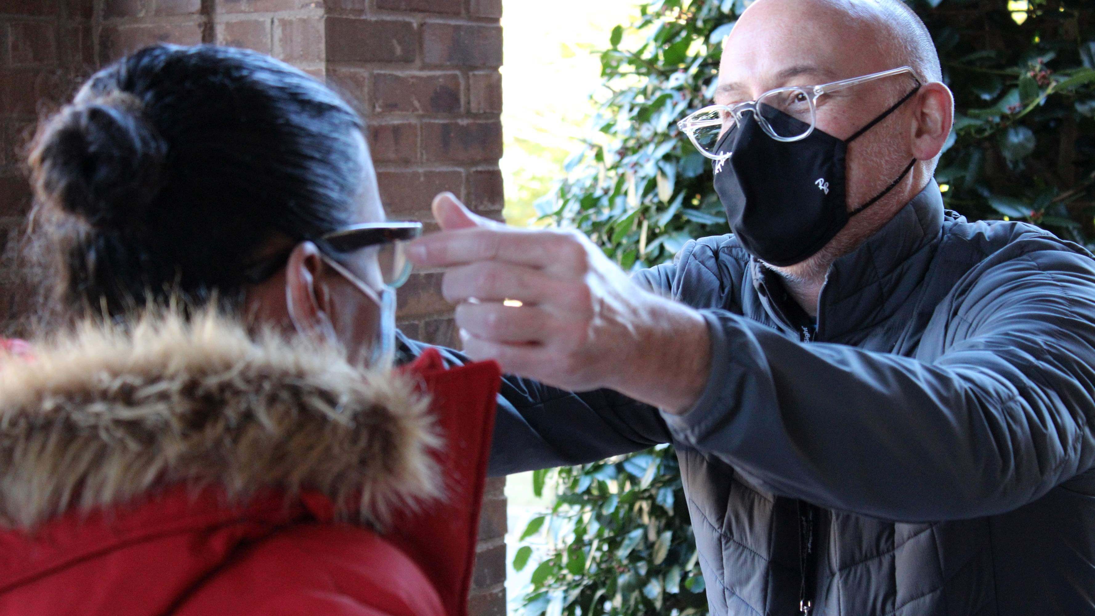 Jon, an OneSight staff member, fits a pair of glasses on a young child in North Atlanta, Georgia.