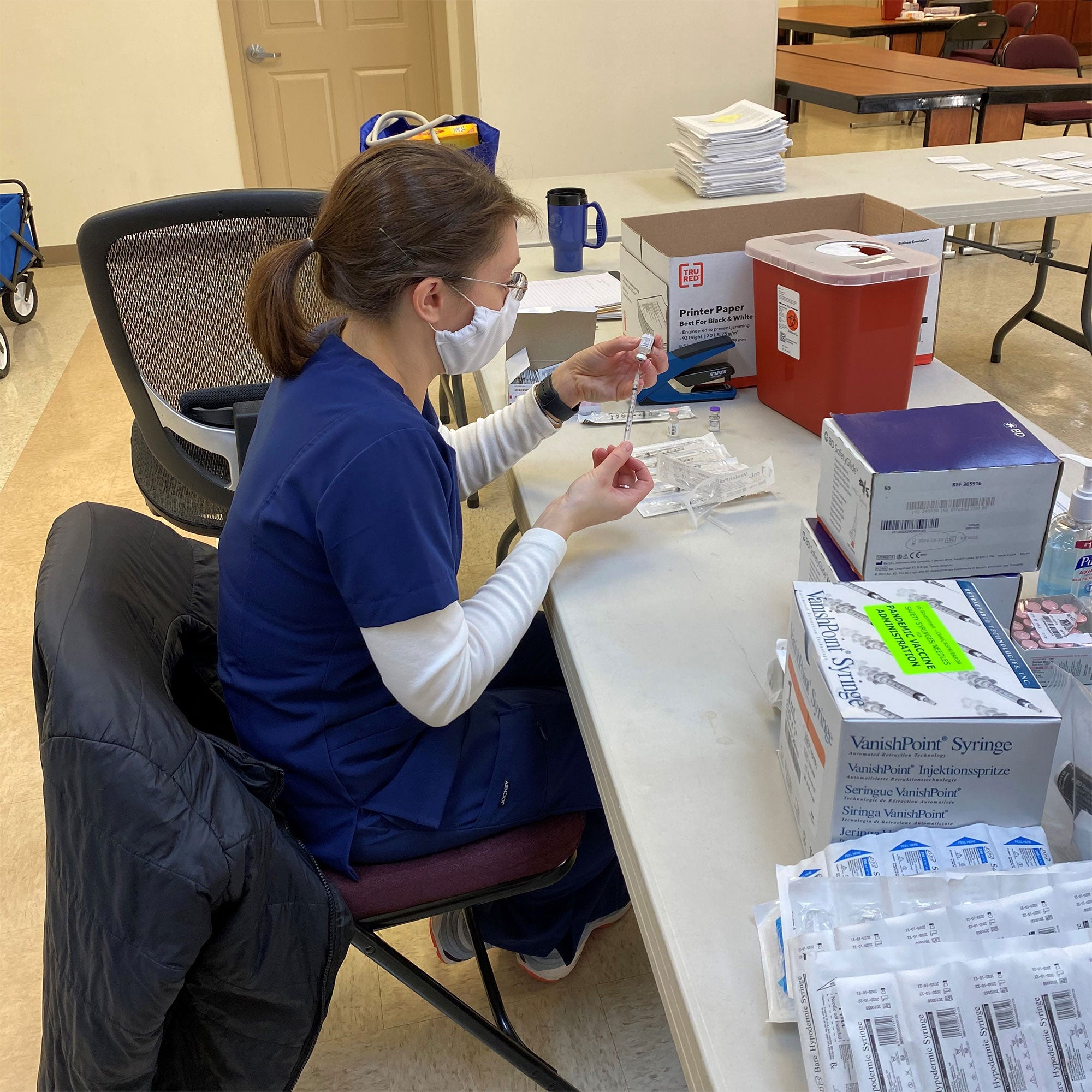 Major Alison Ney prepares vaccination doses.