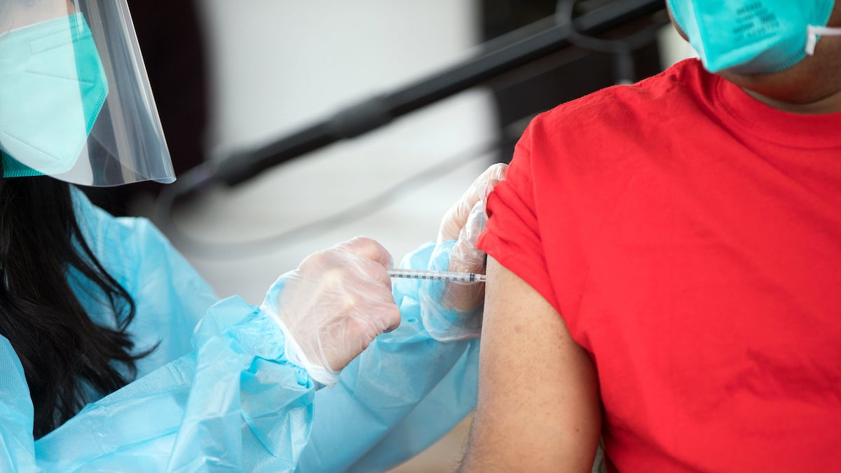 An unknown person receives a COVID-19 vaccination.