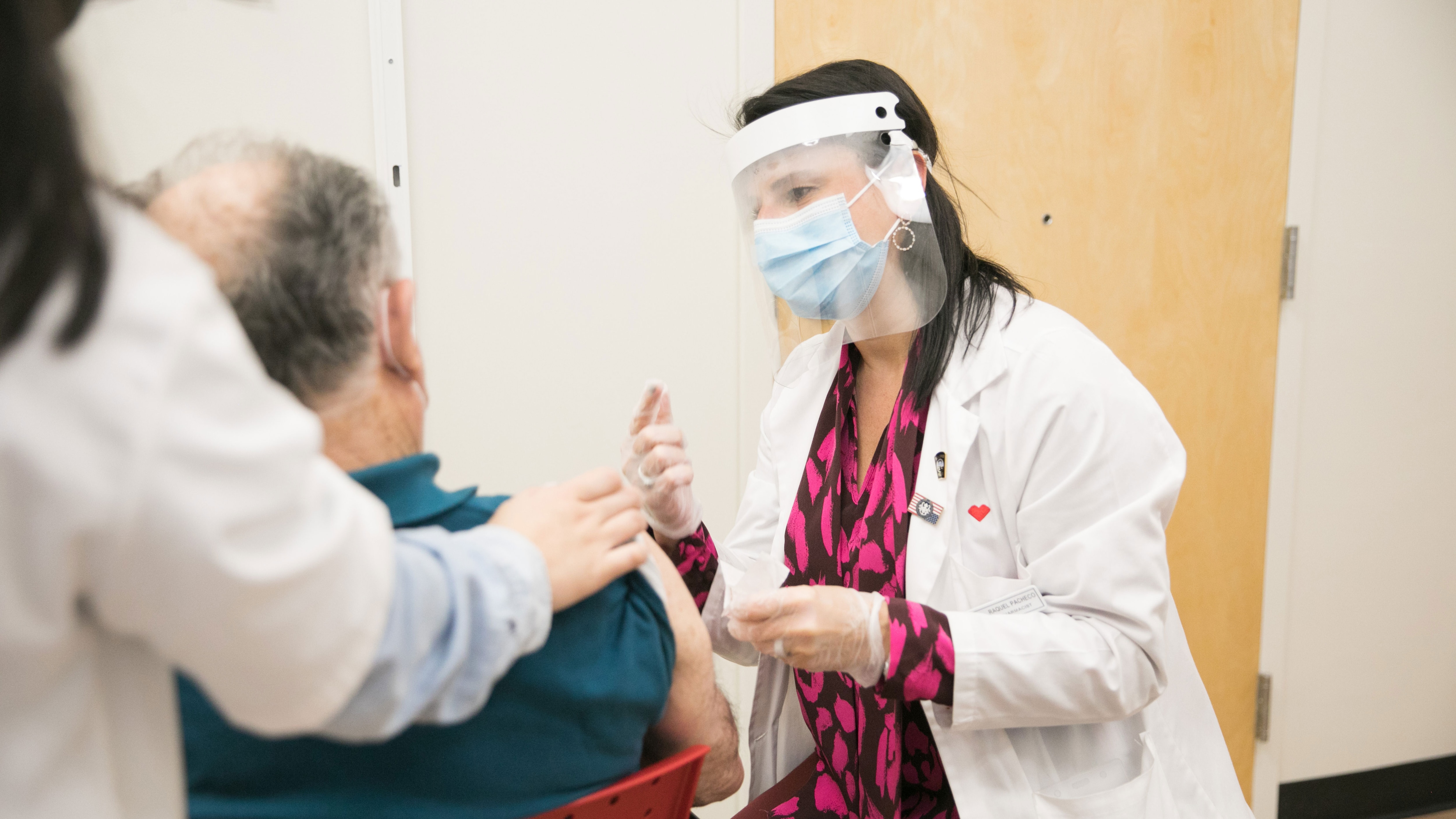 A CVS MinuteClinic practitioner prepares to administer a COVID-19 vaccine.