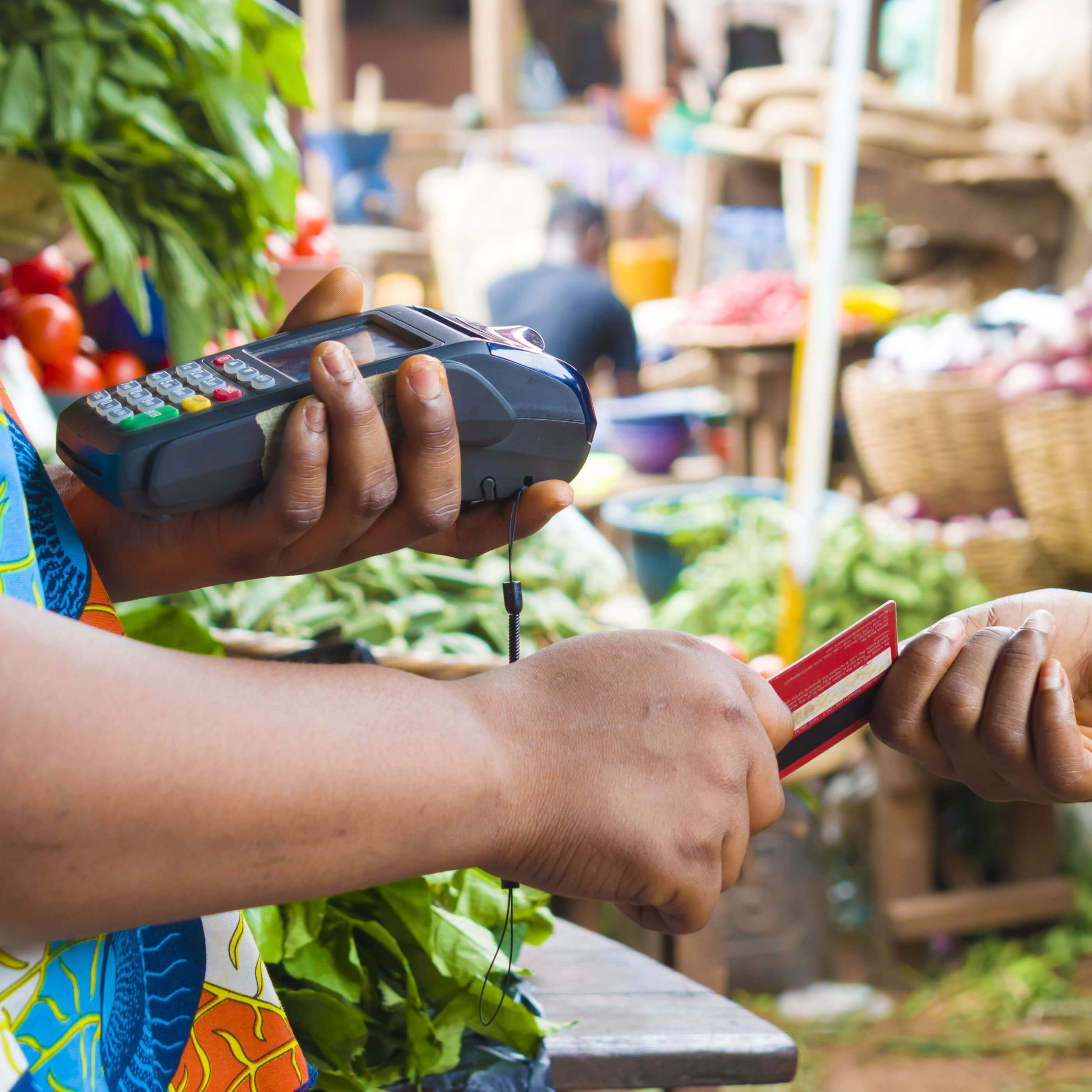 A person paying with a credit card at a farmers market 