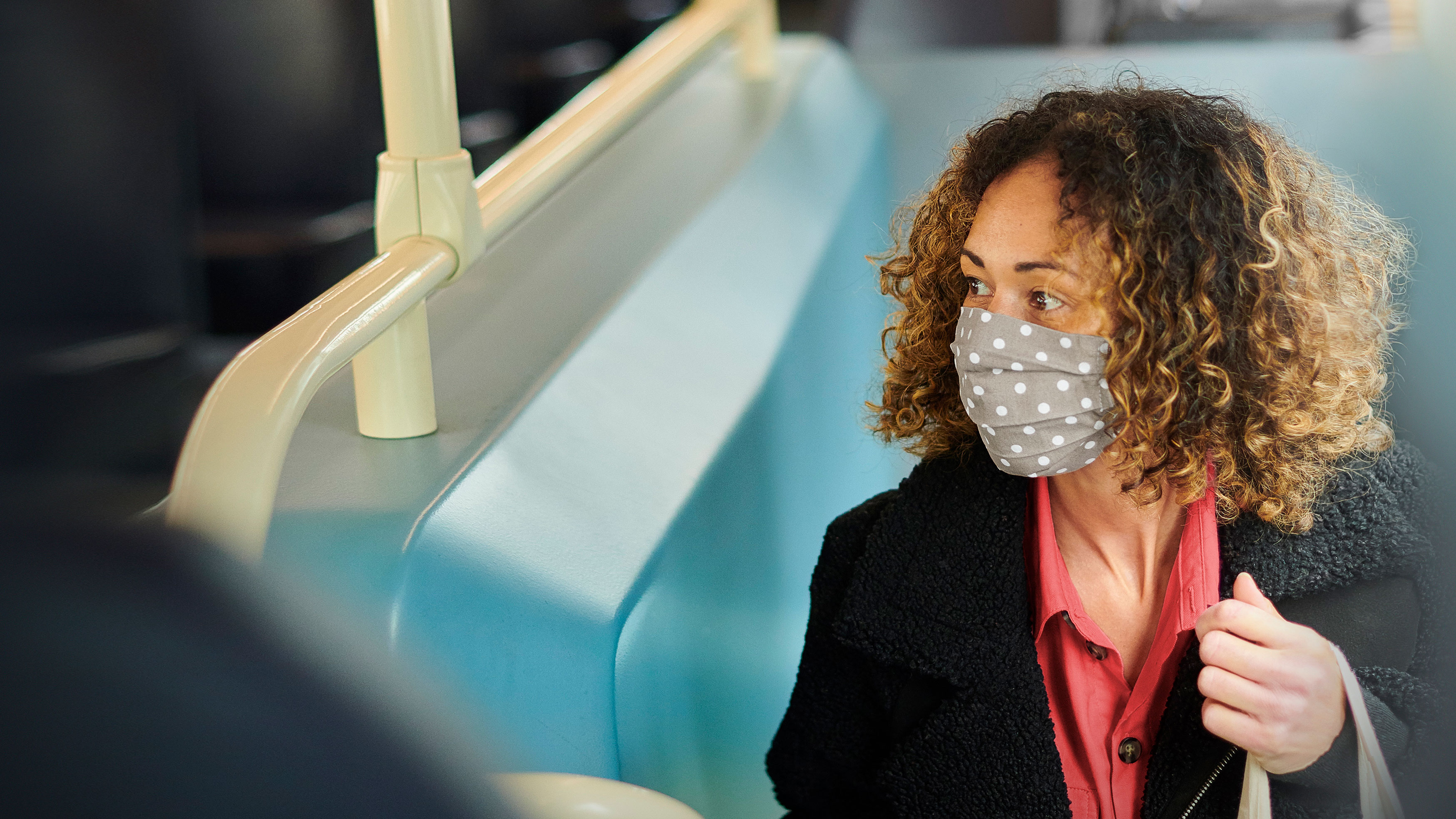 A woman wearing a mask travelling on public transportation