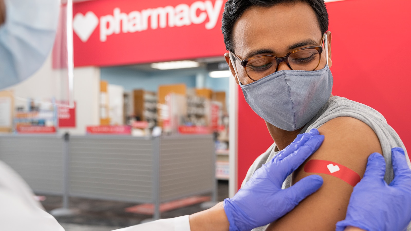 A healthcare provider puts a bandage on a patient&#039;s arm at a CVS Pharmacy location.