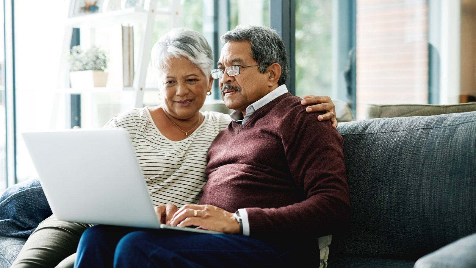 Dos personas jubiladas utilizan una computadora portátil.