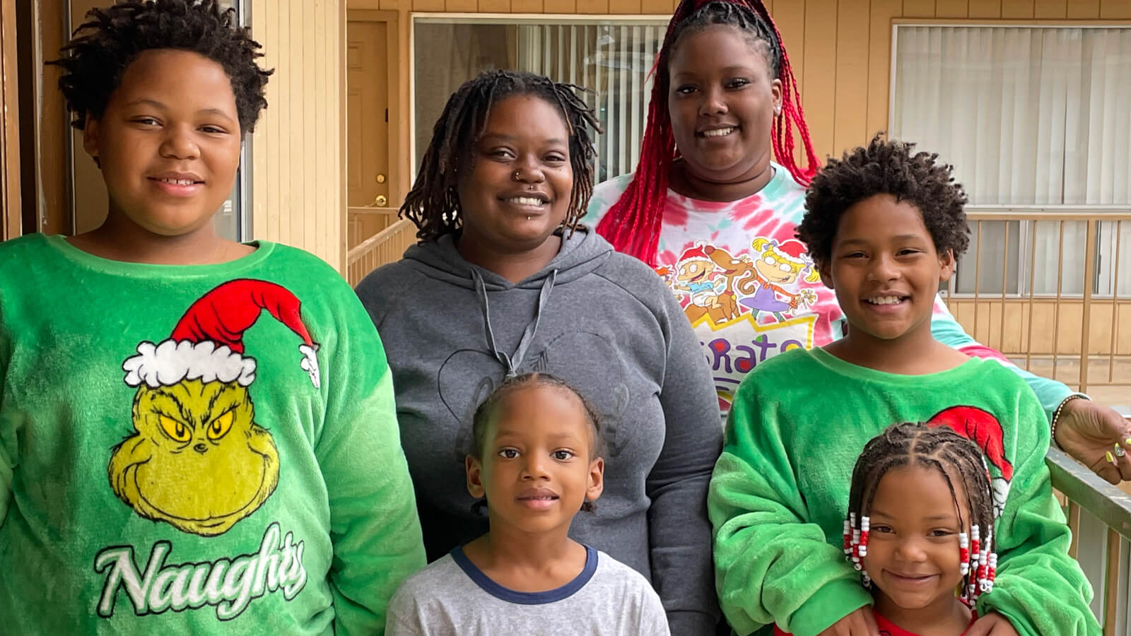 Sabrina McMiller and her family smile outside the front door of their new home.