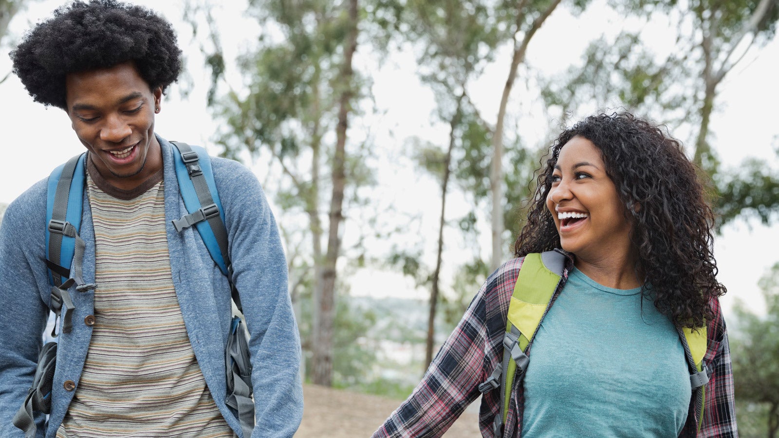A smiling couple out for a stroll are holding hands.
