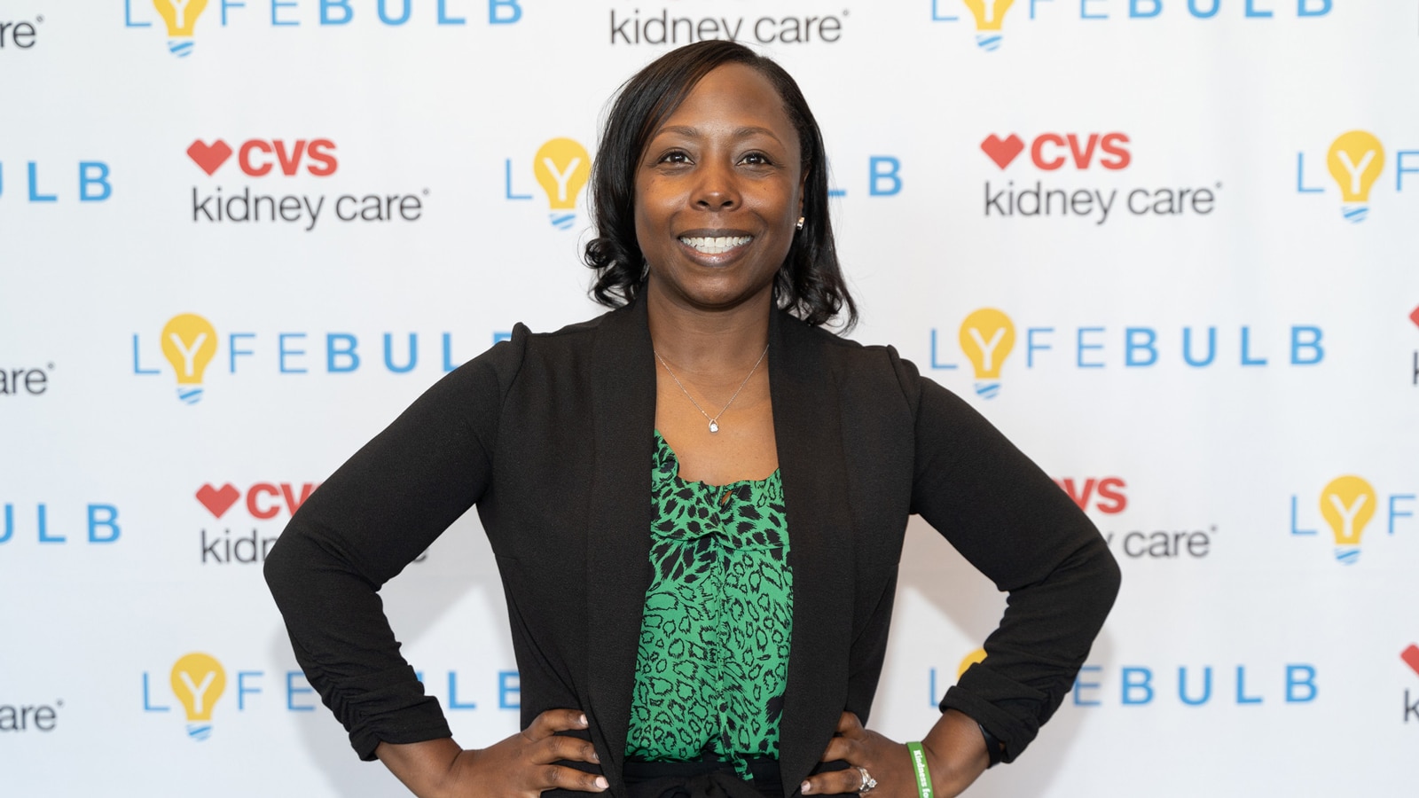 Sharron Rouse smiles in front of a display with the CVS Kidney Care and Lyfebulb logos.