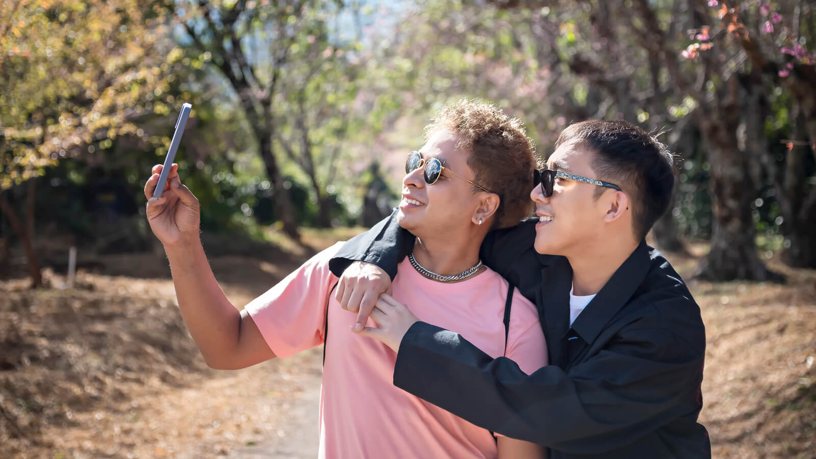 A same sex couple takes a selfie together.