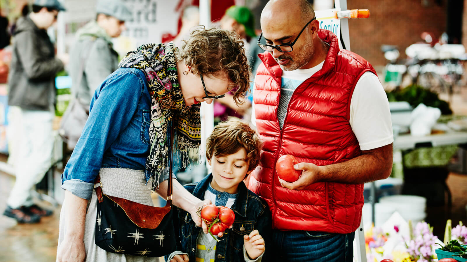 A family of three shop at the market together.