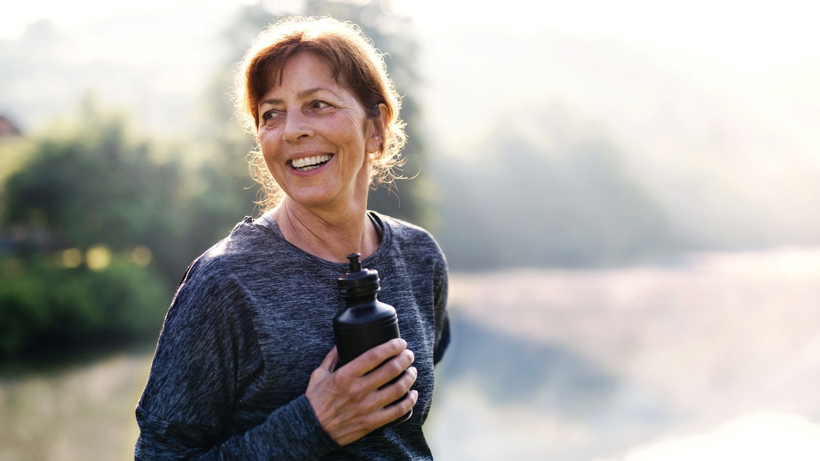 A woman runs with a bottle of water.